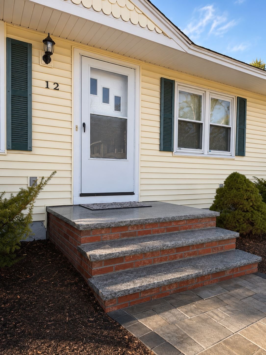 Granite tread steps with brick risers at a front entry, a Truestone steps and entryways project