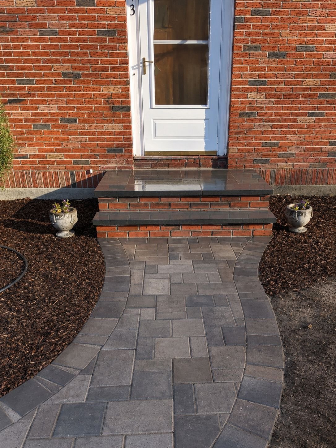 Brick entry steps with a curved paver walkway
